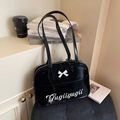 Glossy black crescent shoulder bag with white bow detail and Gugiigugii lettering - Black