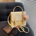Chic light yellow crossbody bag with rhinestone accents and cute bear charm on sofa - Yellow