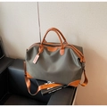 Détail du sac de voyage vert olive avec poignées en cuir marron et bandoulière réglable - Vert