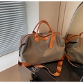 Détail du sac de voyage vert olive montrant les poignées en cuir et la toile texturée - Khaki