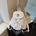 White nylon drawstring backpack with black MUTING embroidery in a minimalist interior - Off White