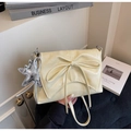 Detail of cream pleated faux leather bag with bow decoration and silver star charm - Yellow