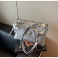 Detail of silver metallic leather bag featuring oversized bow and star charm on books - Silver