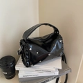 Borsa a cilindro nera con dettagli a balze e borchie a cuore argento su libri d'epoca - Nero