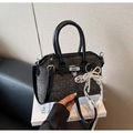 Detail view of denim handbag with pearl bow charm and silver twist lock closure - Black with Pendant