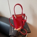 Glossy red faux leather bucket bag with top handles and a matching elephant charm - Burgundy