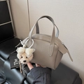 Taupefarbene Handtasche aus Kieselleder im Doctor-Bag-Stil mit beigem Bären-Anhänger - Elefantengrau mit Anhänger