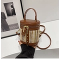 Detail der gewebten Stroh-Beuteltasche mit dunkelbraunem Lederbesatz und Goldnieten - Braun