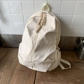 Minimalist beige campus backpack with drawstrings and side pockets in a lifestyle setting - White