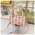 Detailed view of pink mini Boston bag with bear pattern and textured leather surface - Pink
