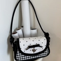 Detail of vintage crossbody bag featuring velvet bow and heart pendant on checkered fabric - Black