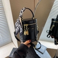 Black glossy cylinder bucket bag with gold lock detail and silk scarf wrapped handle - Black