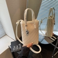 Beige woven bucket bag with metal heart charm and crossbody strap in elegant mirror setting - Off-white