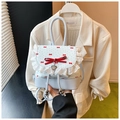 Detail of blue polka dot backpack with red bows, lace trim and silver heart charm - Blue