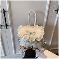 Close-up of white lolita backpack featuring lace ruffles, leather bow, and pearl charm - White