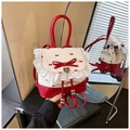 Detailed shot of sweet lace trim and red bow accents on a stylish ballet-style backpack - Red