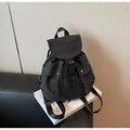 Detailed view of black checkered backpack with flap buckle and front snap pockets - One Size / Black