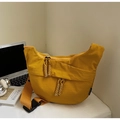 Yellow crescent canvas crossbody bag with woven zipper pull on a white office desk - Yellow Large