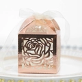 Close-up of laser-cut rose gold candy box with floral patterns and a white ribbon - Reflective Rose Gold