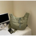 Detail view of green nylon crescent bag featuring woven zipper and adjustable buckle strap - Green Large