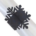 Macro detail of laser-cut black snowflake napkin ring with intricate hollowed patterns - Black