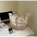 Detail of beige crescent canvas bag with pleated texture and woven zipper pullers - Rice White Large