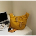 Detail of yellow nylon dumpling bag featuring dual zippers and woven rope pulls - Yellow Small