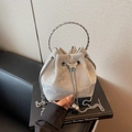Silver-grey suede bucket bag featuring round metal handle and pearl butterfly charm - Silver