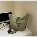 Detail view of sage green nylon crescent bag with woven zipper cords and buckle - Small / Green
