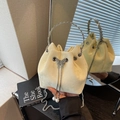 Pale yellow suede drawstring bucket bag with silver butterfly charm and pearl details - Yellow