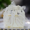 Macro shot of laser cut wedding candy box with bride and groom silhouette and ribbon - Ivory
