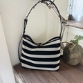 Woven tote bag with black and white stripes featuring leather straps and wood button - Black