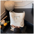 Detail of cream bow shoulder bag with butterfly print and pearl charm on black steps - White