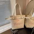 Creamy white tote bag with pink bow decoration and elegant metallic belt buckle detail - Off-white