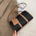 Black pebbled leather bowling bag with brown trim and adjustable crossbody strap - Black