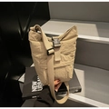 Detalle del bolso bandolera de nailon beige con hebilla negra en escaleras urbanas - Talla única / Caqui