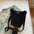 Detail van een zwarte canvas crossbodytas met gespsluiting en functionele ritsen - Zwart