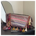 Close-up of bohemian woven bag with colorful tassels and ethnic pattern wide strap - Red