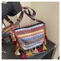 Close-up of bohemian crossbody bag with colorful woven patterns and tassel details - Blue