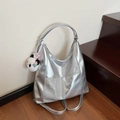 Silver metallic tote bag with panda pendant shown on a modern indoor staircase background - Silver