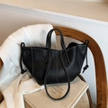 Sac fourre-tout minimaliste en cuir noir avec surpiqûres blanches sur une chaise en bois - Noir