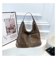 Close-up of deep brown glossy tote bag with punk style silver rivets on front pockets - One Size / Coffee