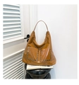 Detailed view of glossy brown leather tote with silver rivets and dual front pockets - One Size / Brown