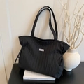 Black quilted tote bag with pleated drawstring design and logo patch for daily commute - Black