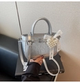 Detail of silver metallic crossbody bag featuring pearl heart charm and lace bow decor - With Charm / Silver