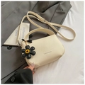 Detail of cream white leather handbag with lychee pattern and daisy flower charm - White with Pendant