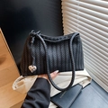 Elegante borsa a spalla intrecciata nera con ciondolo a cuore e texture raffinata - Nero