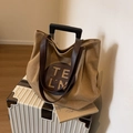 Grand sac cabas en toile kaki avec anses marron posé sur une valise blanche - Kaki