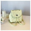Detalle de mochila acolchada amarillo crema con cierre de giro plateado y cadena - Amarillo