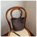 Détail de la texture tressée du sac seau marron foncé et de sa bandoulière en cuir lisse - Marron